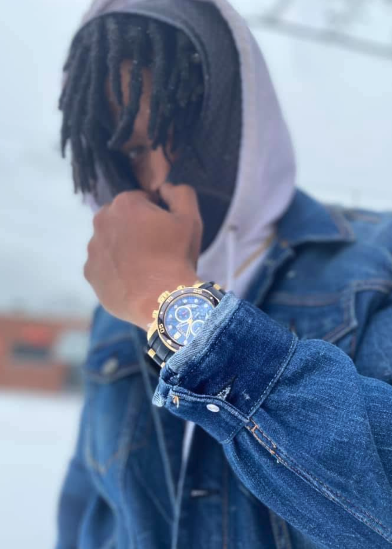 Sl1ck N°1 in denim jacket with watch, snow backdrop